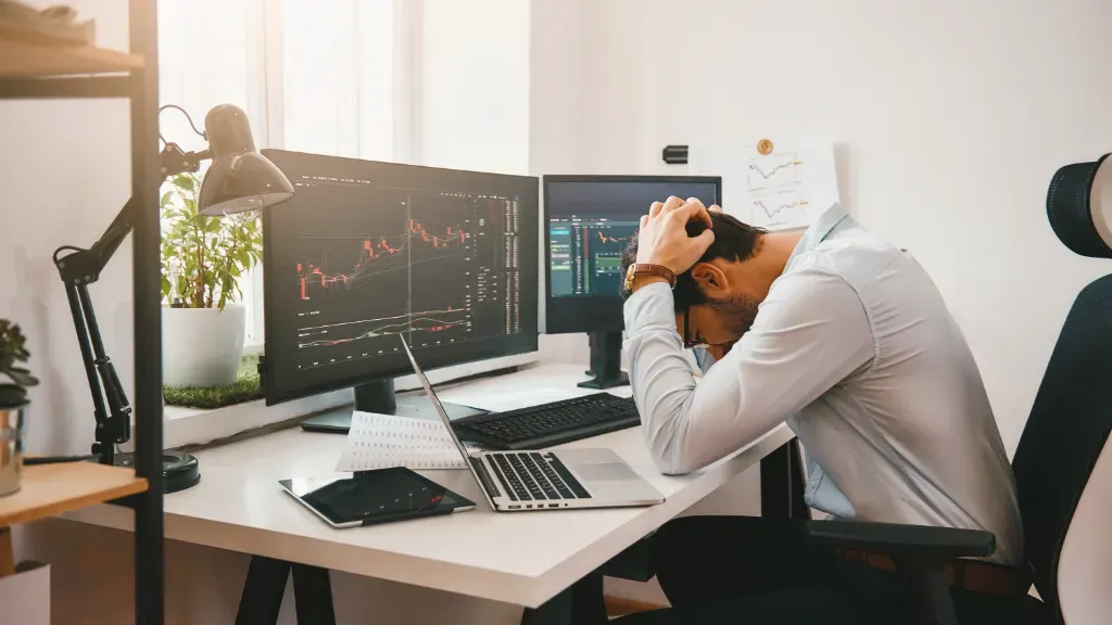 Początkujący trader, który popełnił błąd na rynku forex, trzyma się rękami za głowę